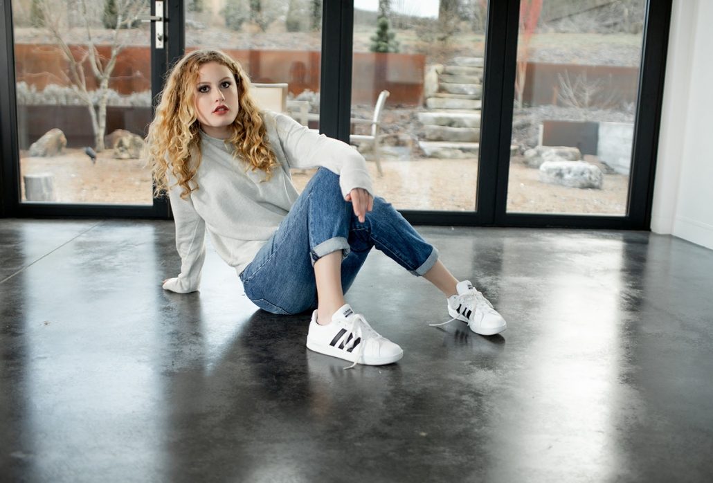 Woman Models Gray Sweater and White Adidas Style Sneakers For Frock Boutique