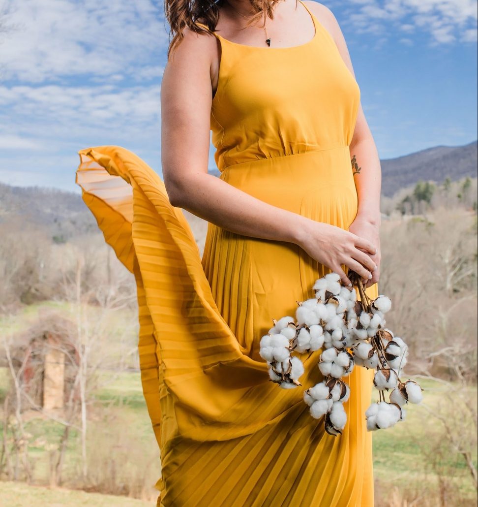 Woman Models Yellow Dress Holding Flowers For Frock Boutique Asheville NC