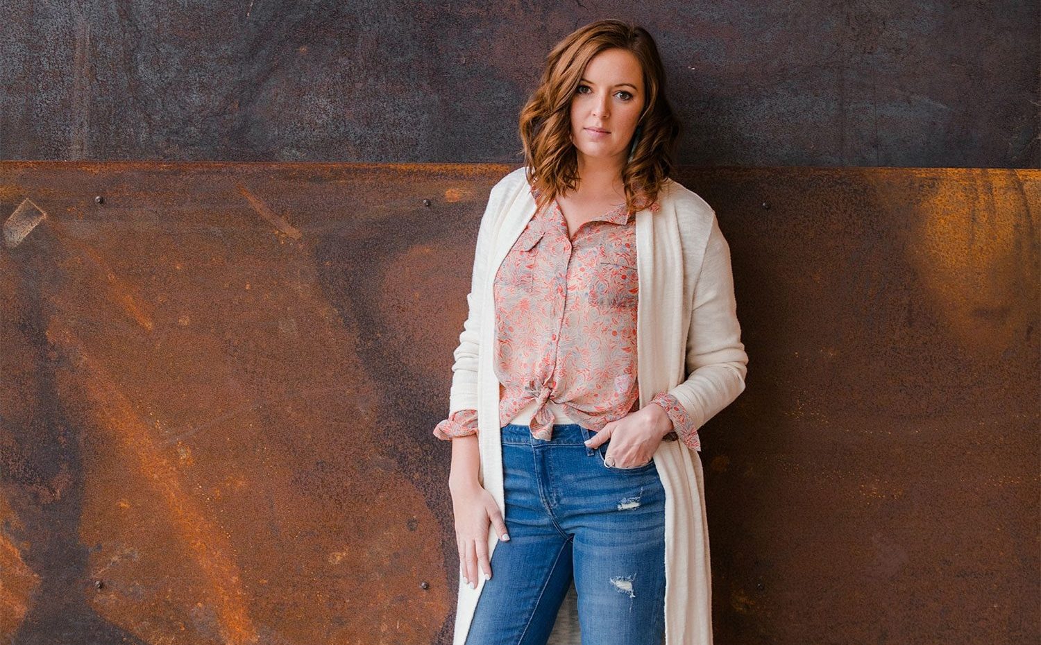 Woman Wearing A White Cardigan And Rose Colored Top Modelling For Frock Boutique Asheville NC